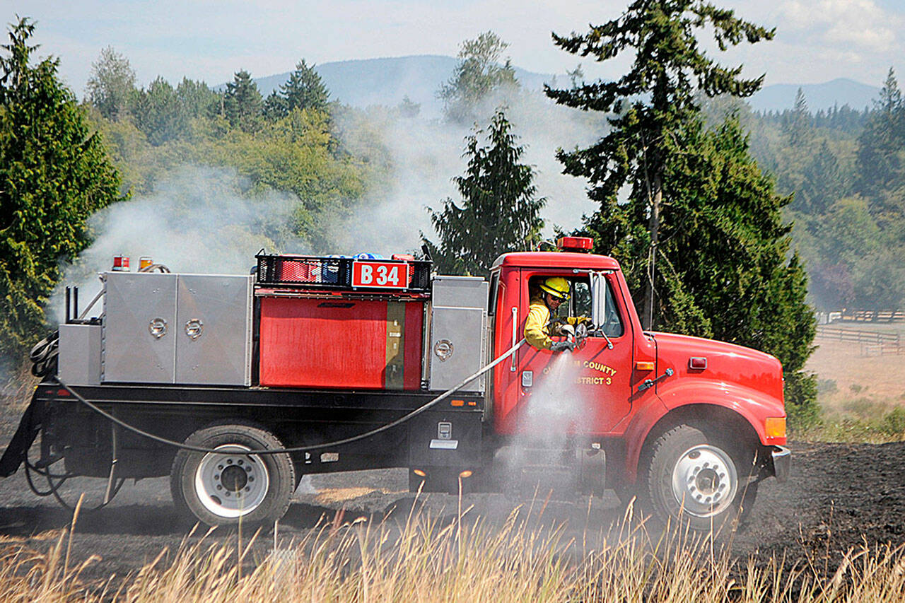 Sequim Gazette file photo by Matthew Nash
Officials with Clallam County Fire District 3 plan to make a decision in 2023 whether or not to go to voters to approve more funding to add staff, apparatuses and/or new fire stations. Here, firefights fight a brush fire in July 2021 west of Sequim.