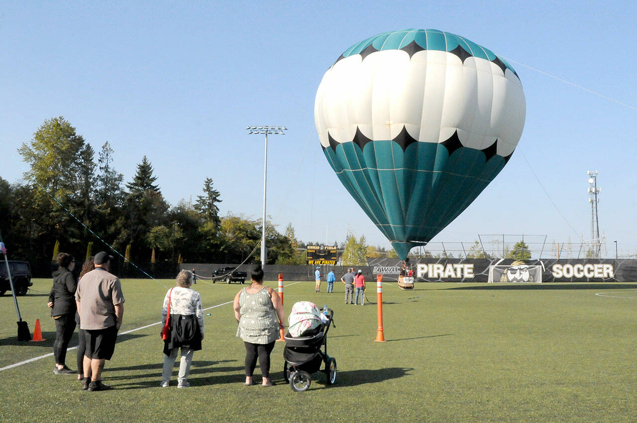 Photo by Keith Thorpe/Olympic Peninsula Daily News Group / A hot air balloon rises from the soccer field of the Wally Sigmar Athletic Complex at Peninsula College in Port Angeles for tethered rides on Oct. 1, as part of the Peninsula College Fall Spectacular. The event, hosted by the school to bring the community to the campus, also featured displays and demonstrations, children’s activities, food and music.