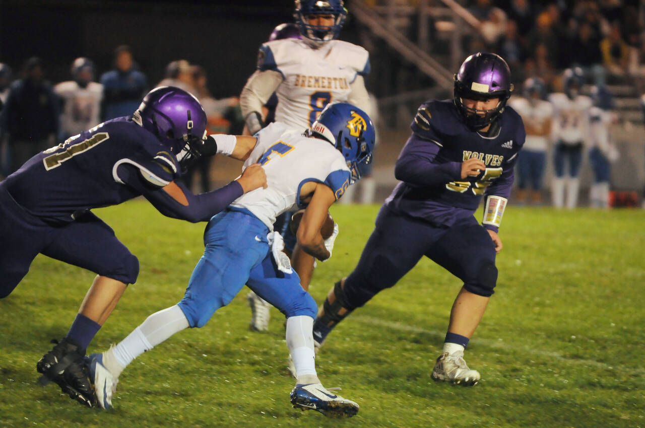 Sequim Gazette photo by Michael Dashiell / Sequim’s Saul Williams, left, and Ayden Holland tackle Bremerton running back Jayden Quenga in the first half of an Oct. 28 Olympic League game.