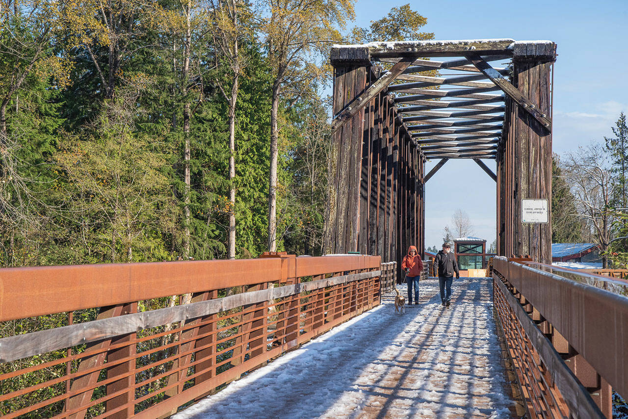 Sequim Gazette photo by Emily Matthiessen/ Visitors walk the Dungeness River Railroad Bridge on Tuesday, Nov. 8, amid melting snow that fell starting the evening before.
