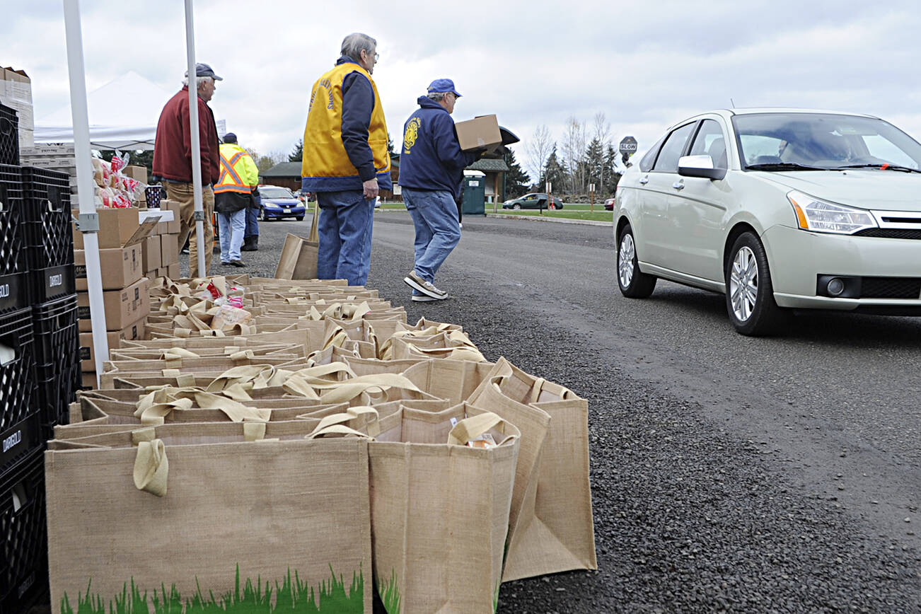 Sequim Gazette file photo by Matthew Nash
Volunteers at last November’s Holiday Meal Bag Distribution day stock up vehicles as they drive through Carrie Blake Community Park. The event is held again 11 a.m.-2 p.m. Friday, Nov. 18, and Dec. 16.