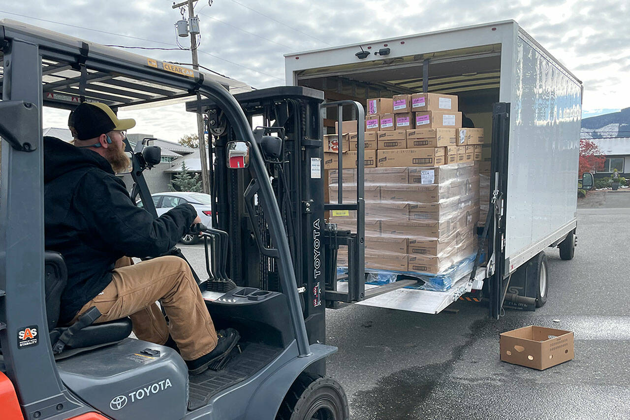 Sequim Gazette photo by Matthew Nash/ Josh Forberg, safety and logistics coordinator for Sequim Food Bank, unloads 1,200 pumpkin pies from Safeway on Nov. 10 that will be provided during the Holiday Meal Bags Distribution event on Nov. 18 in Carrie Blake Community Park.