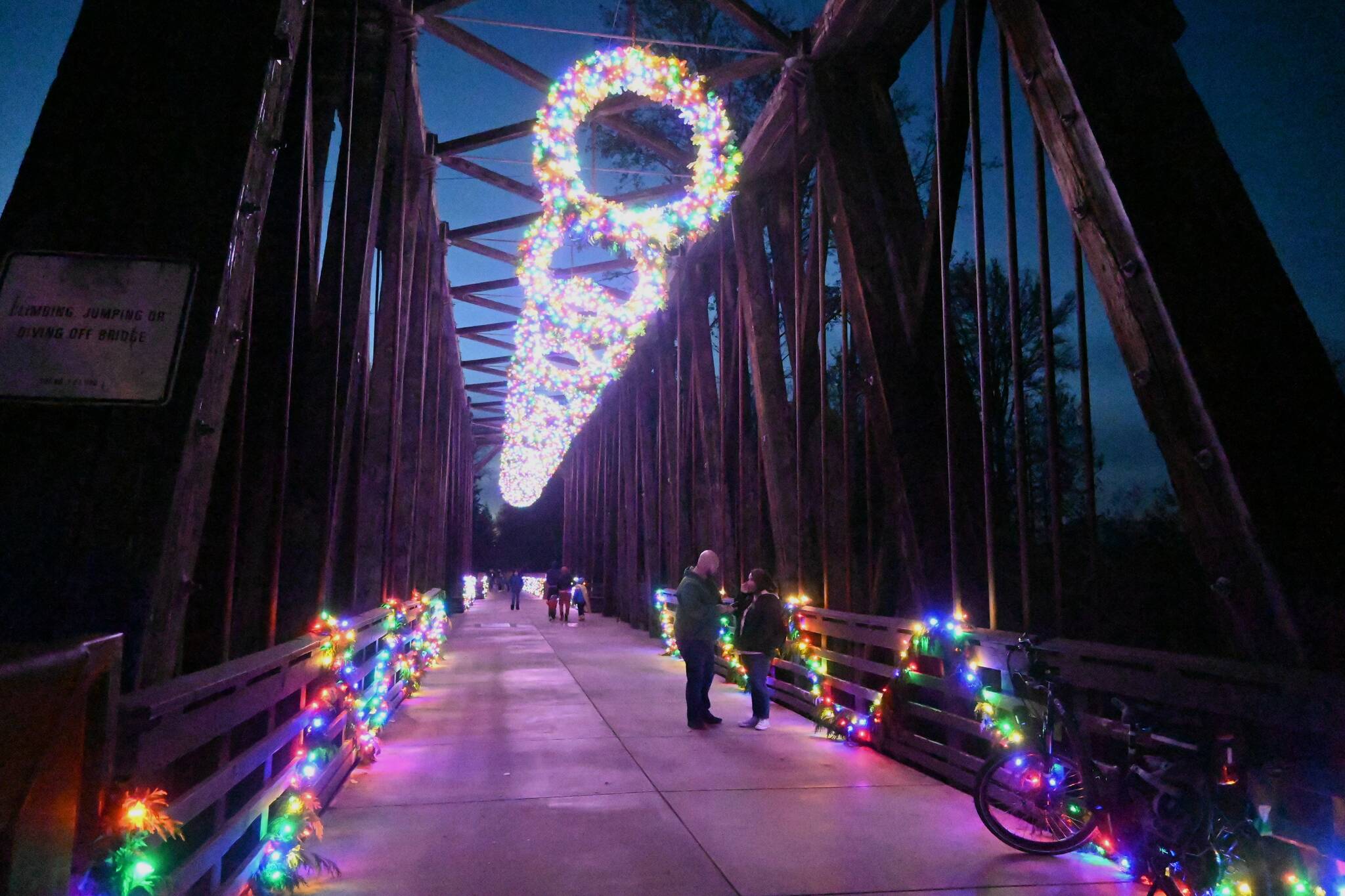 Sequim Gazette photo by Michael Dashiell / Visitors enjoy holiday-themed lighting the historic Railroad Bridge at Railroad Bridge Park on Saturday, Nov. 19. The annual River Center Holiday Nature Mart at the park’s Dungeness River Nature Center, held Saturday and Sunday Nov. 19-20, coincided with Saturday’s bridge lighting. The bridge’s lights will be on display each day at 3 p.m. through December.