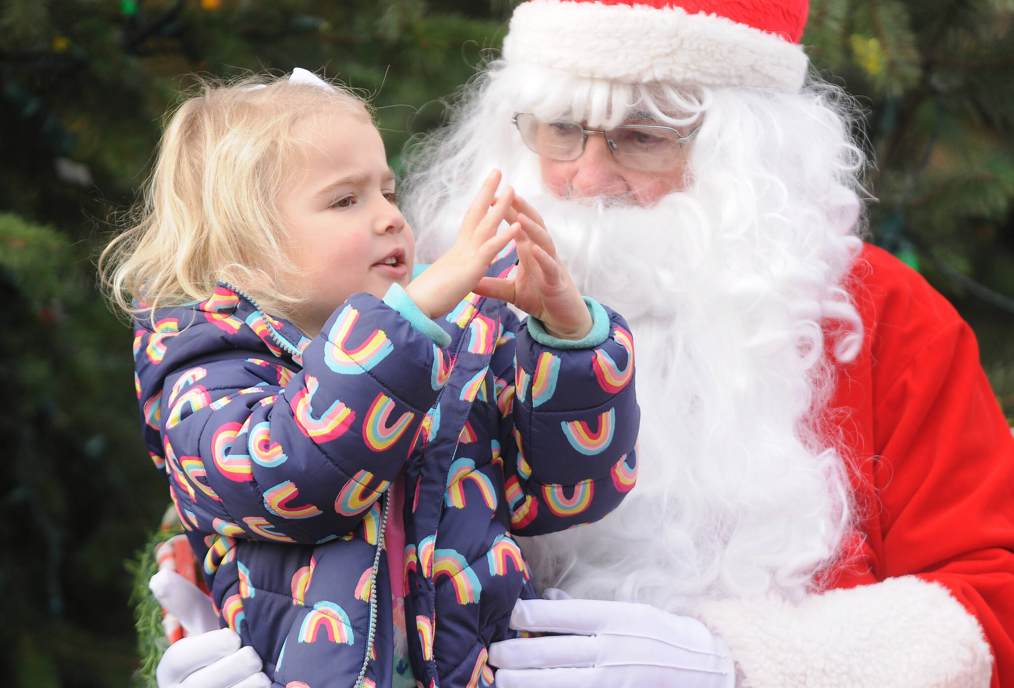 Sequim Gazette photo by Michael Dashiell / Finley Loveless, 3, of Sequim, spends some quality time with Santa Claus (Stephen Rosales) at the Hometown Holidays event Saturday afternoon in downtown Sequim.