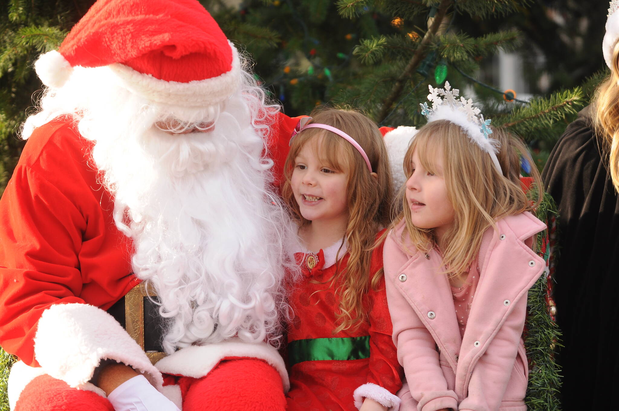 Above: Silver Newell, center, and Lucy Johnson, both 5-year-olds from Sequim, talk with Santa Claus (Stephen Rosales) at the Hometown Holidays event Saturday afternoon in downtown Sequim. The pair are best friends from preschool.
