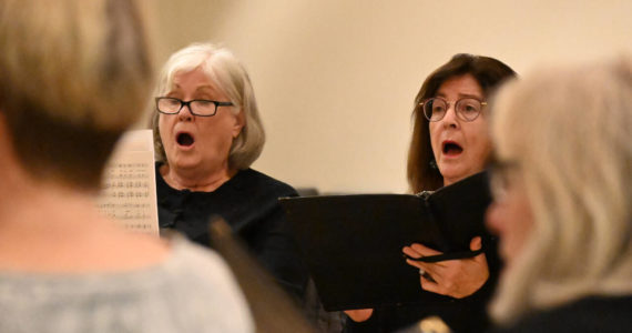 Sequim Gazette file photo by Michael Dashiell / Peninsula Singers Patty Shoop, left, and Andria Richey rehearse for the group’s fall concert in November. The group will conduct auditions on Thursday, Jan. 5, for their gala Spring Concert, scheduled for the end of April.
