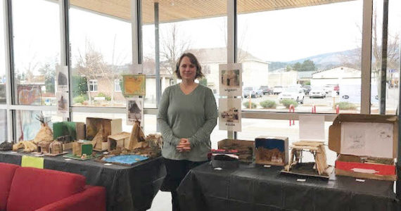 Submitted photo / Olympic Peninsula Academy teacher Rebecca Bullard stands near student dioramas, on display at the Sequim Civic Center through the first week of January.
