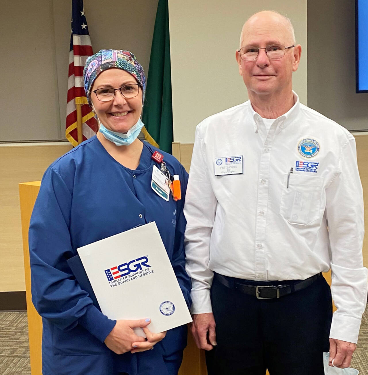 Photo courtesy of Olympic Medical Center / Sarah Winfield, OMC Manager of Surgical Services Sarah Winfield, left, accepts the Patriot Award from Phil Sanders, Washington State Chair of the Employer Support of the Guard and Reserve.