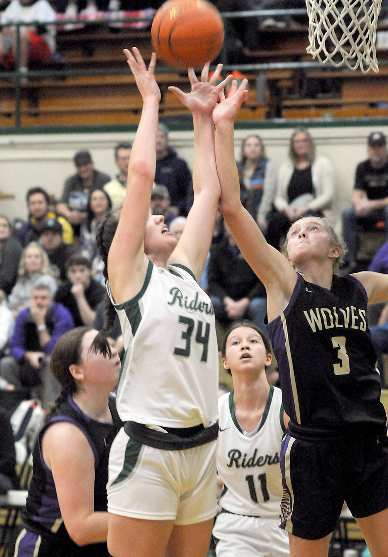 Photo by Keith Thorpe/Olympic Peninsula News Group / Port Angeles’ Lexie Smith, left, and Sequim’s Jolene Vaara vie for a rebound as Sammie Bacon of Sequim, lower left, and Lindsay Smith, rear, look on during a Jan. 10 game at Port Angeles High School.