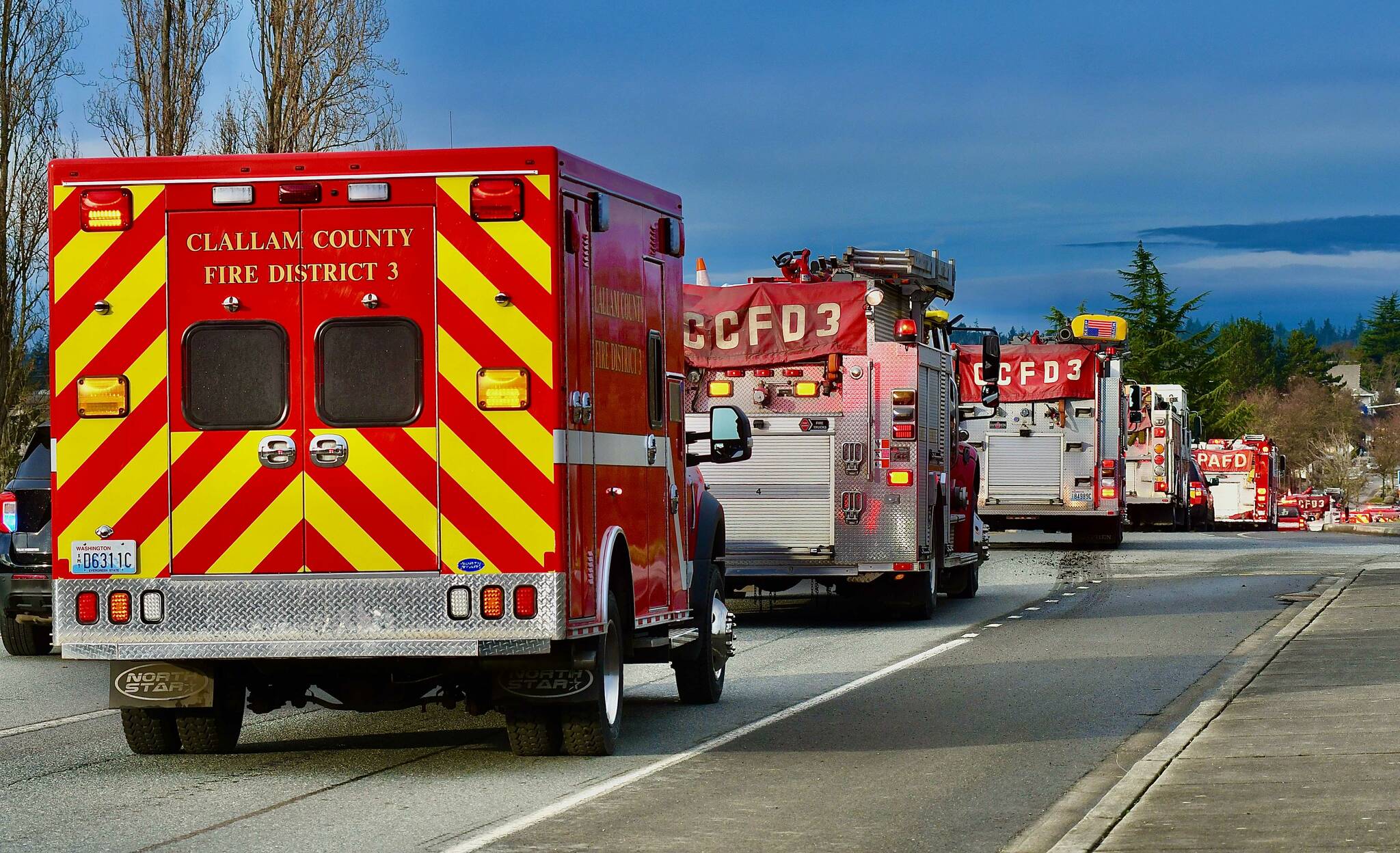 Photo by Jay Cline
First responders honor the passing of Capt. Charles “Chad” Cate with a procession of vehicles on Jan. 13, pictured here coming into Sequim off U.S. Highway 101.