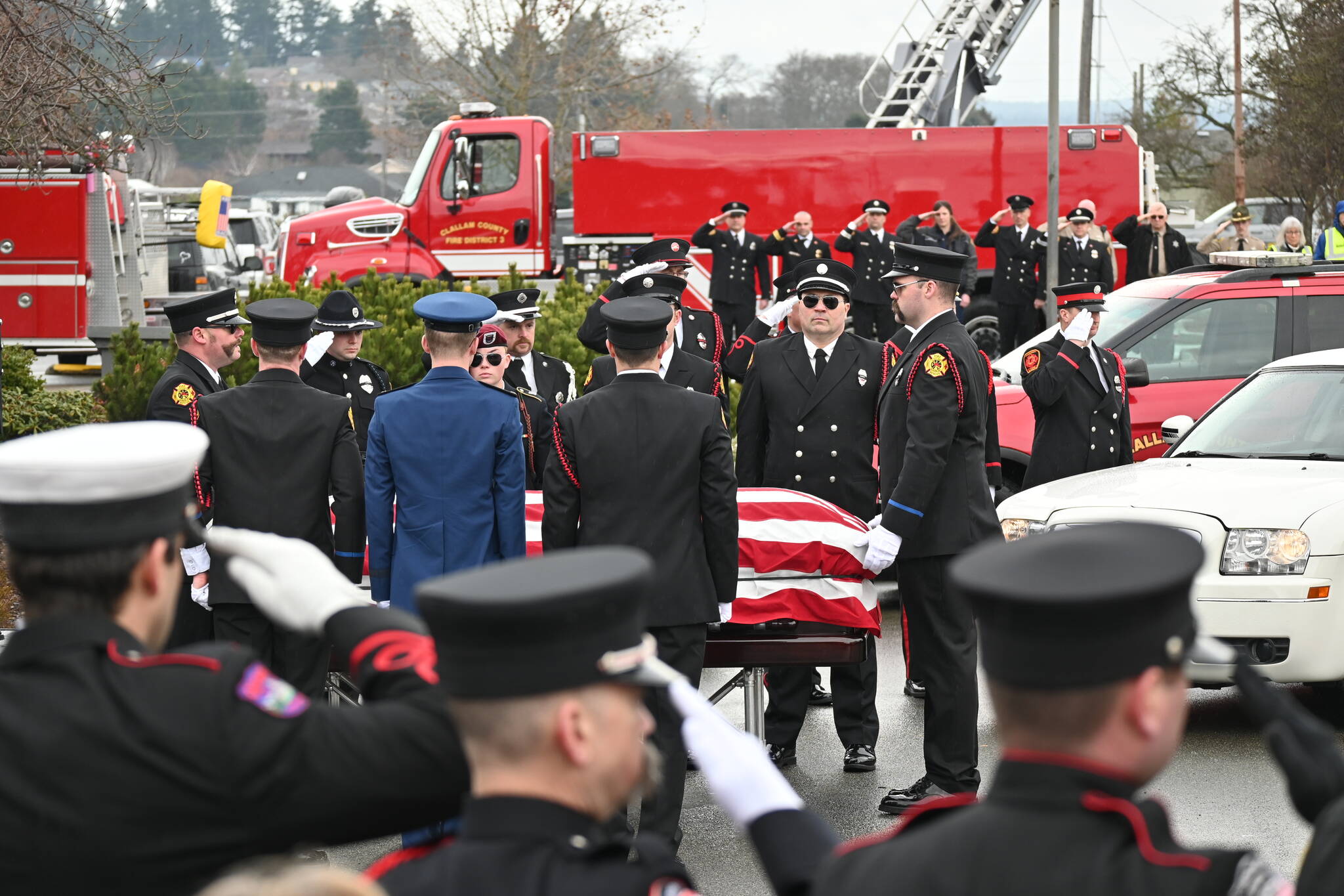 Sequim Gazette photo by Michael Dashiell / Firefighters pay tribute to Capt. Charles “Chad” Cate at a memorial service at Sequim High School on Jan. 21.