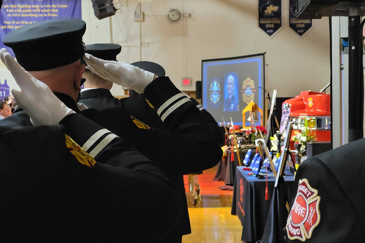 Firefighters pay tribute to Capt. Charles “Chad” Cate at a memorial service at Sequim High School on Jan. 21.