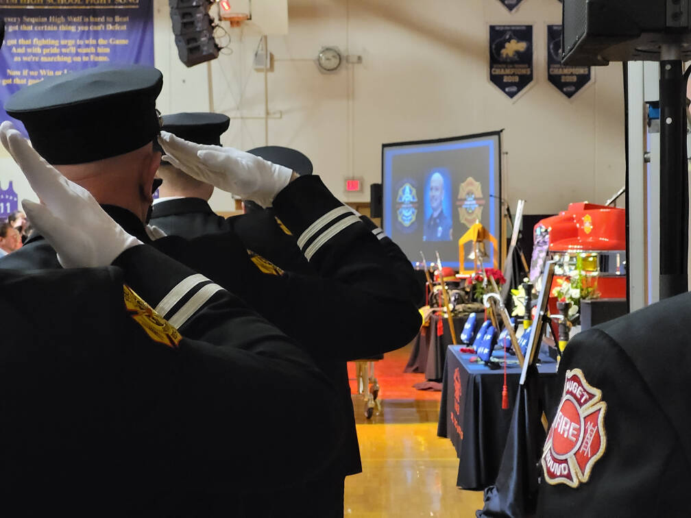 Sequim Gazette photo by Michael Dashiell / Firefighters pay tribute to Capt. Charles “Chad” Cate at a memorial service at Sequim High School on Jan. 21.