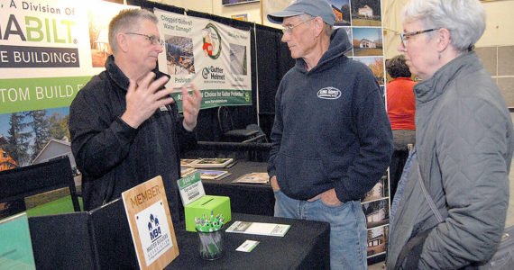 Keith Thorpe/Peninsula Daily News
Will Johnson of Lynnwood-based PermaBilt Post Frame Buildings, left, speaks with Brad and Marla Varner of Sequim at his company's booth at the 22nd annual Building, Remodeling and Energy Expo on Saturday in the gymnasium of Sequim High School. The event, hosted by the North Peninsula Building Association, features a variety of vendors and exhibits covering a wide range of building trades.  The expo continues today from 9 a.m. to 3 p.m. Admission is free.