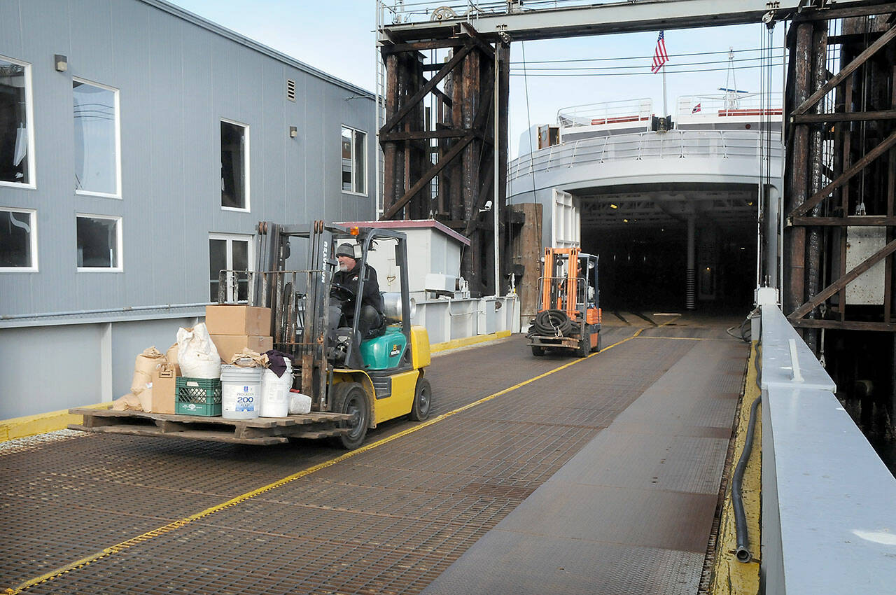 Photo by Keith Thorpe/Olympic Peninsula News Group
Able seamen Doug Reader, front, and Brandon Melville drive forklifts as they offload equipment from the ferry MV Coho after its return to Port Angeles from annual dry dock maintenance in Anacortes on Jan. 25. The ferry resumed regular service between Port Angeles and Victoria last week.