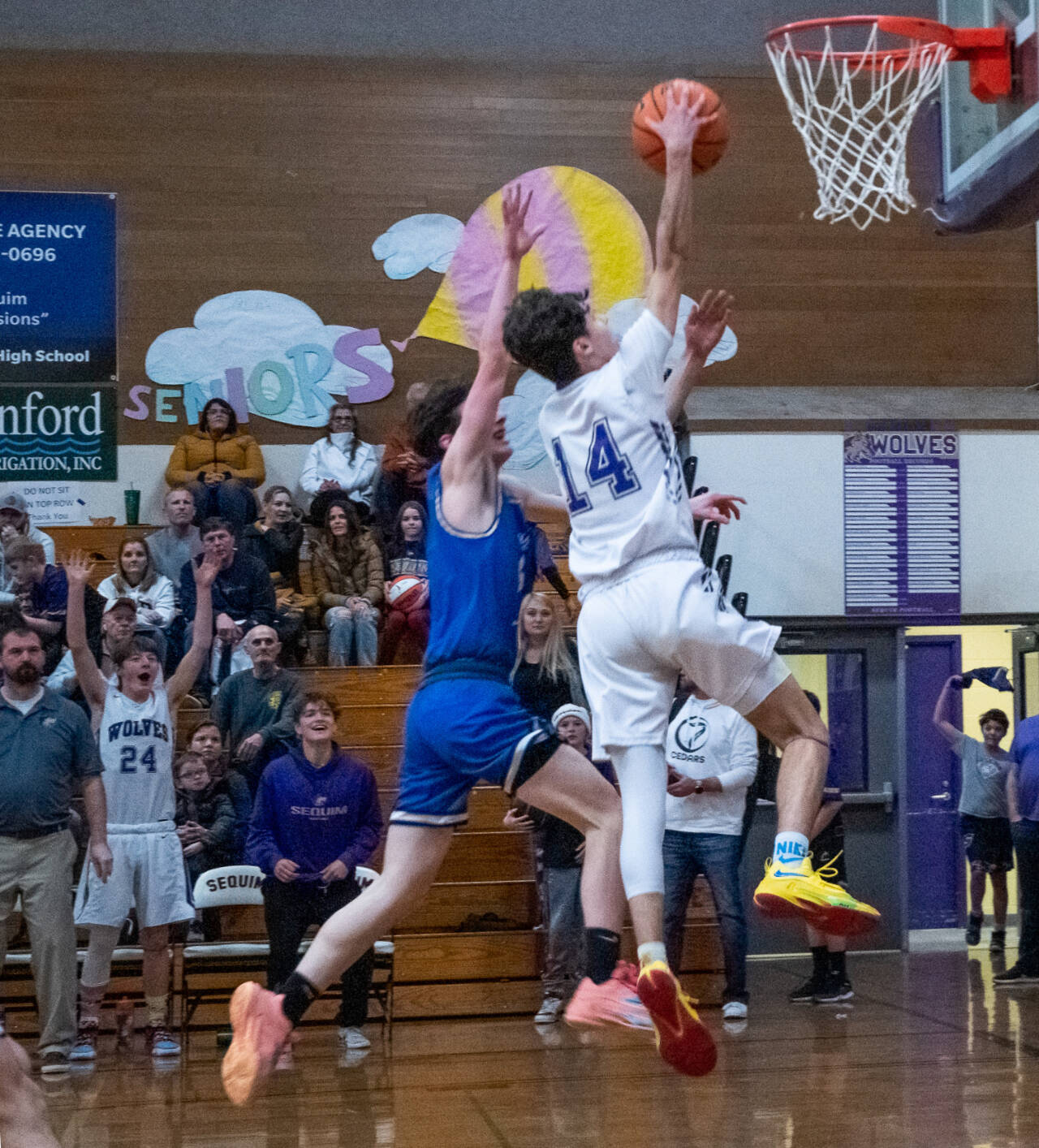 Sequim’s Vince Carrizosa drives past Bulldog Cole McCormick to the basket for a score in the Wolves’ 64-44 Olympic League win over North Mason.