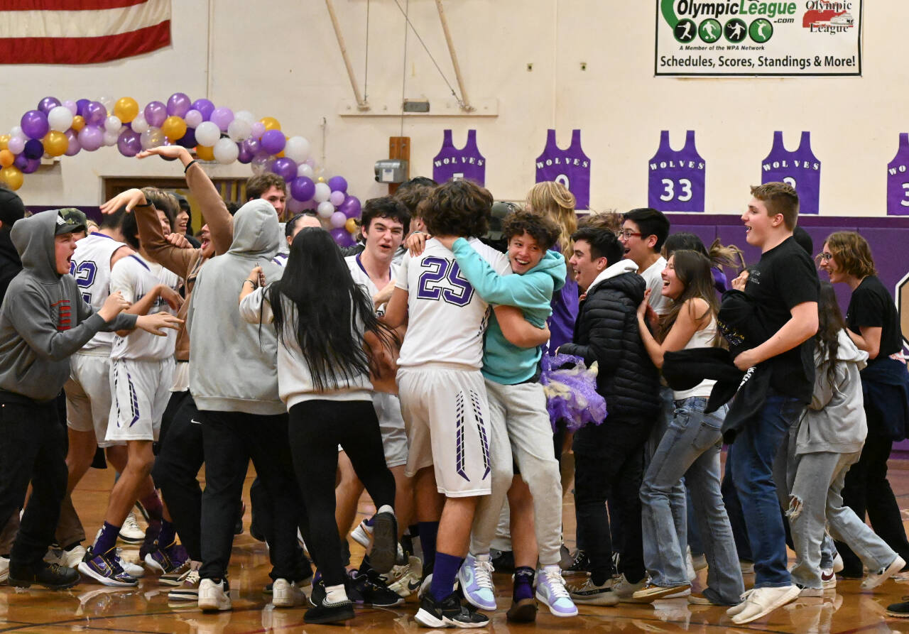 Sequim fans storm the court moments after the SHS boys knocked off No. 19-ranked Port Angeles, 60-57, on Feb. 2.