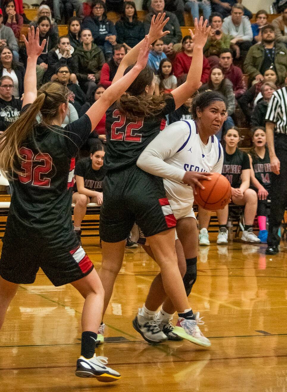 Sequim Gazette photo by Emily Matthiessen / Sequim’s Jelissa Julmist, right, looks to score as Neah Bay’s Ryana Moss (32) and Amber Swan (22) defend in a Feb. 7 non-league match-up. Julmist had a double-double with 20 points and 13 rebounds.
