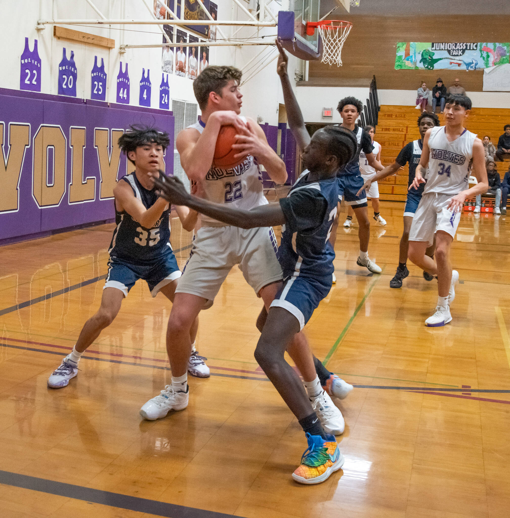 Sequim Gazette photo by Emily Matthiessen / Sequim’s Brett Mote, center, looks to pass as he’s pressured by Lindbergh’s Dylan Villez, left, and John Chuol in a Feb. 15 West Central District tournament game.