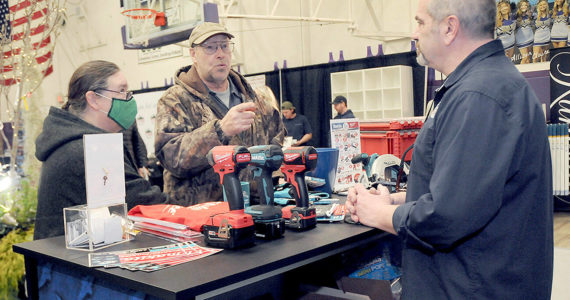 Jack and Marcella Ridge of Sequim talk about power tools with Tony Contestable, tool specialist with Hartnagel Building Supply of Port Angeles, right, during Saturday's 2023 Building, Remodeling & Energy Expo in the Sequim High School gym. The two-day event, hosted by the North Peninsula Building Association, featured a variety of booths, displays and presentations dedicated to home building, repair and remodeling. (Keith Thorpe/Peninsula Daily News)