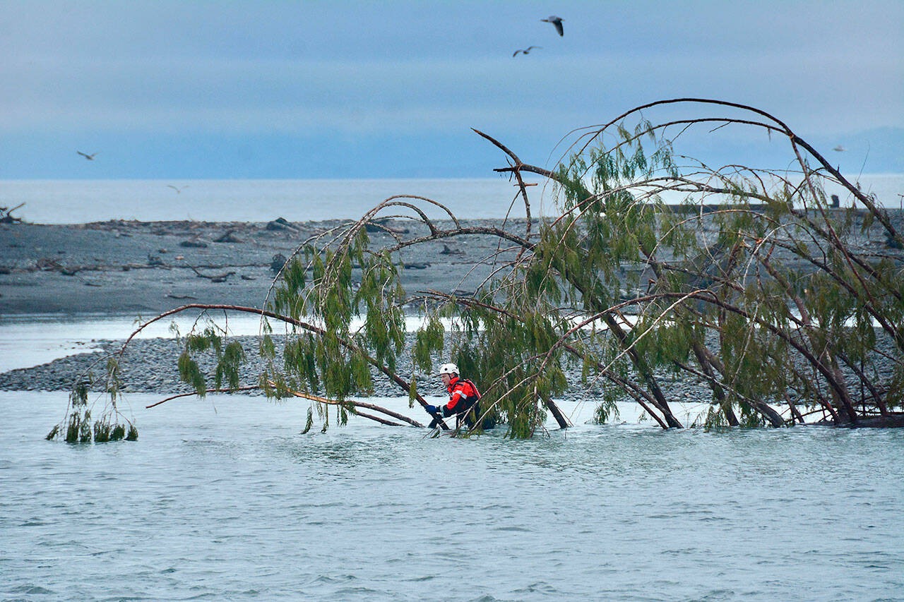 Firefighter-Paramedic Kjel Skov of Clallam County Fire District 3 searches near the mouth of the Elwha River on Monday afternoon. (Jay Cline/Clallam County Fire District No. 2)