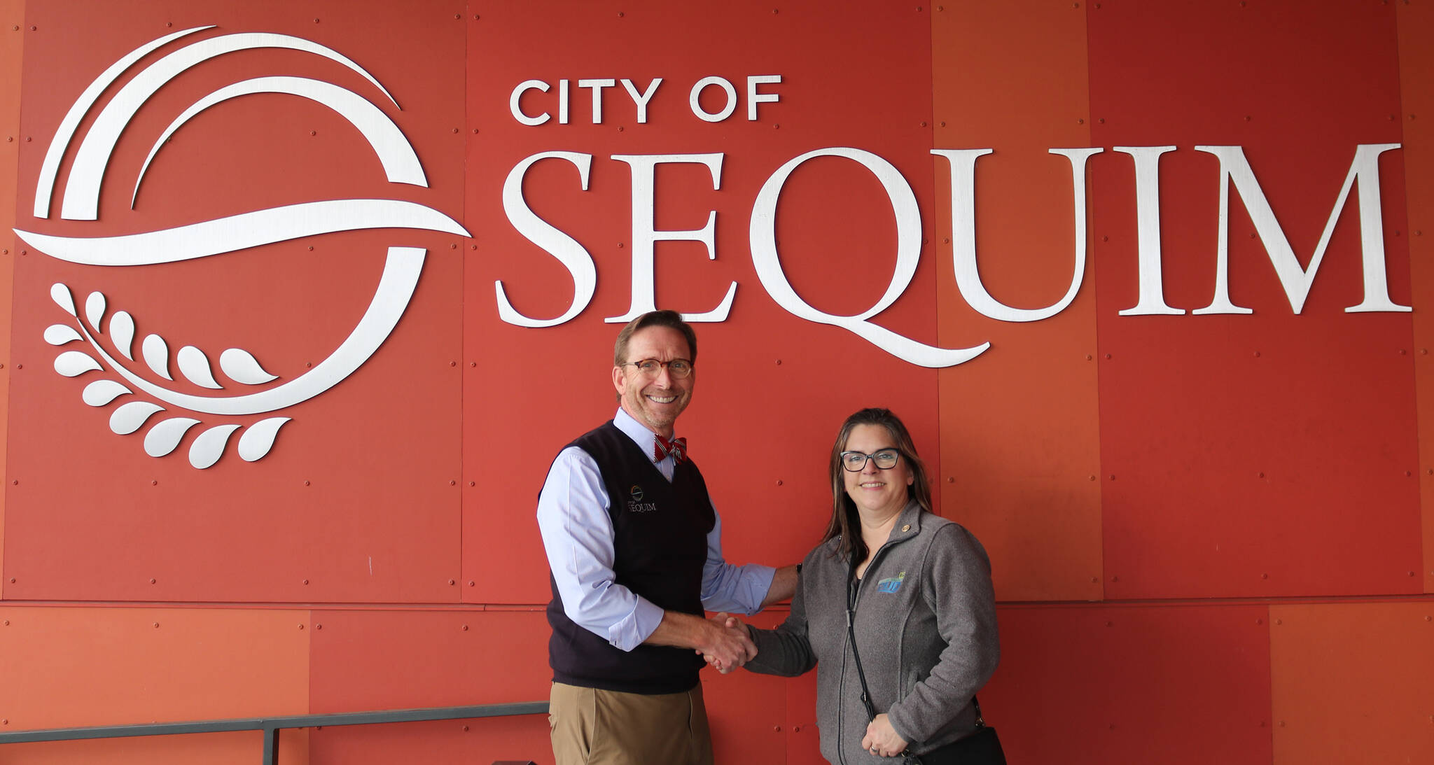 Photo courtesy of City of Sequim / Sequim City Manager Matthew Huish accepts a sponsorship from Nicole Hartman, Communications Manager and Public Records Officer for Clallam County PUD, to sponsor the Sequim Sunshine Festival’s Interactive Light Experience at Pioneer Memorial Park.