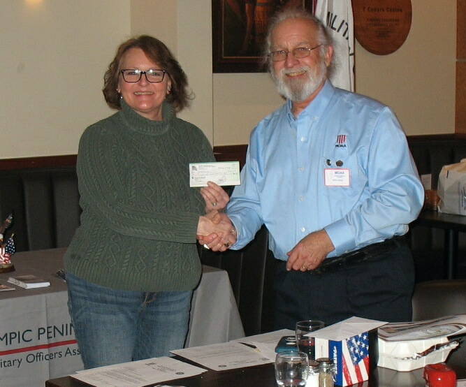 Submitted photo / Richard Havel (U.S. Navy, Ret.), president of the local Military Officers Association of America group, presents a $5,000 donation to Cheri Tinker, president of the North Olympic Peninsula Veterans Housing Network, at a luncheon in mid-February.