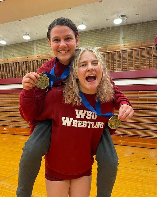 Sequim High grad Petra Bernsten, right, and Julie Wilson celebrate titles in their weight classes at the 2023 NCWA Northwest Conference Championships in Hoquiam in late February. The pair and five other Cougars qualified for the nationals.