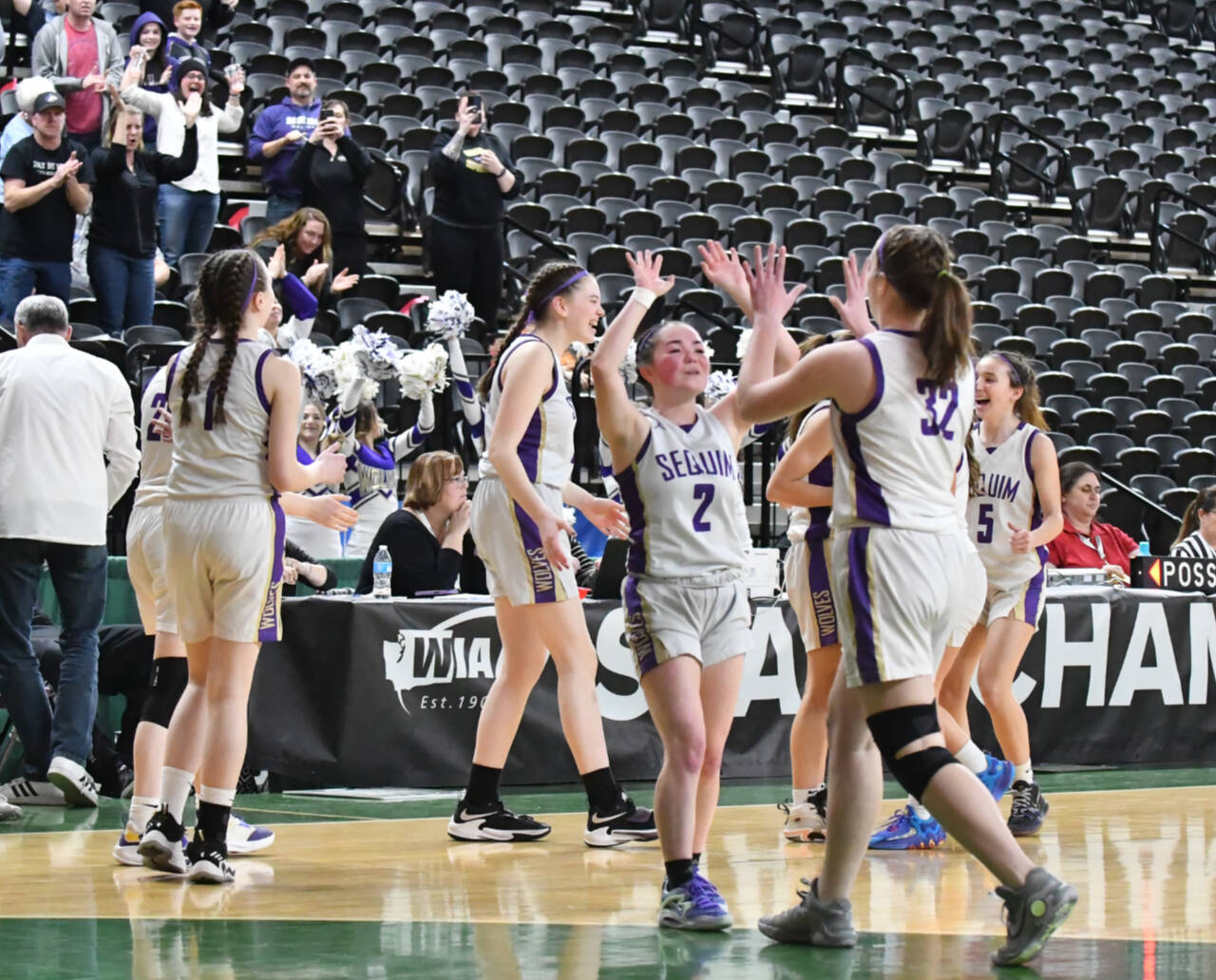 Photo by Jim Heintz / Sequim’s Hannah Bates (2) and Hailey Wagner (32) celebrate the Wolves’ Round of 12 victory of Sammamish at the class 2A state tournament in Yakima on March 1.