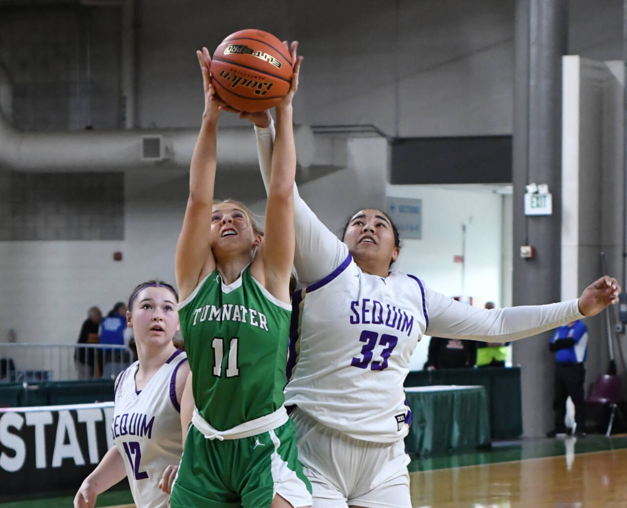 Photo by Jim Heintz / Sequim's Jelissa Julmist (33) and Sammie Bacon and Tumwater's Kylie Waltermeyer vie for the ball in the Wolves' 38-24 win over Tumwater at the class 2 A state tournament on March 3.