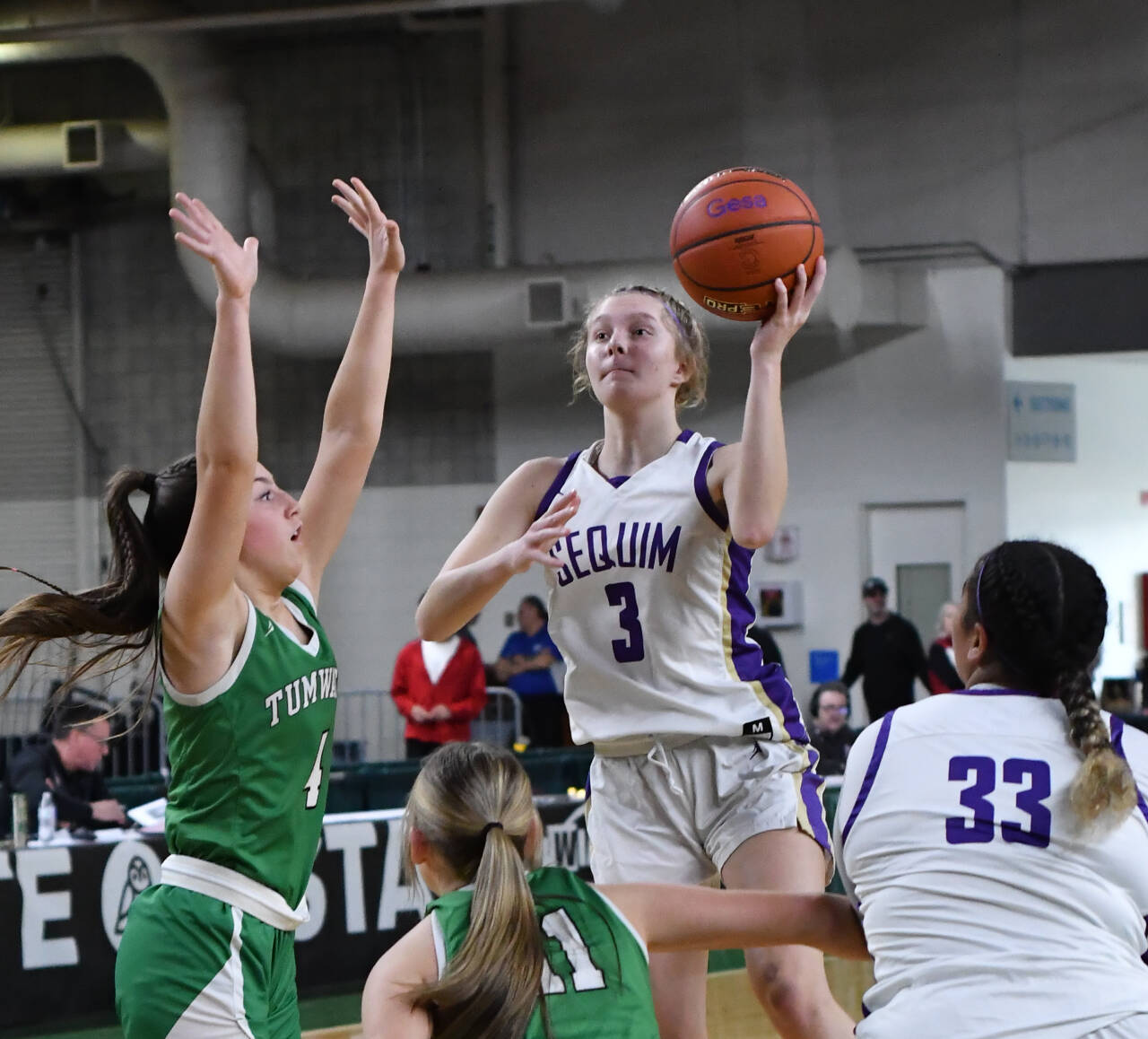 Photo by Jim Heintz /With teammate Jelissa Julmist (33) looking on, Sequim’s Jolene Vaara rises up for a shot in the Wolves’ 38-24 win over Tumwater at the class 2A state tournament on March 3. Defending on the play are Tumwater’s Morgan Simmons (4) and Kylie Waltermeyer.