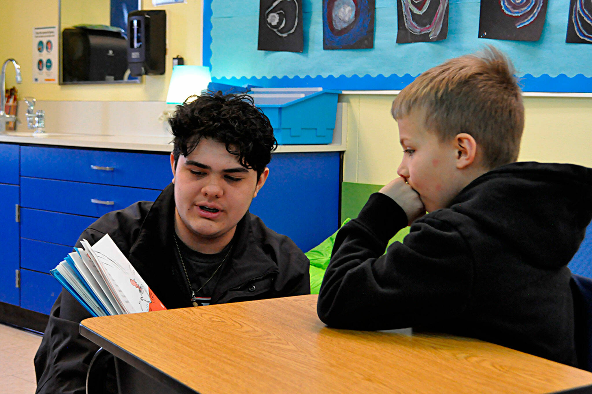 Sequim Gazette photo by Matthew Nash/ Mark Fiso reads a Dr. Seuss book to first grader Finley Liebolt on March 2 at Helen Haller Elementary for Read Across America Day.