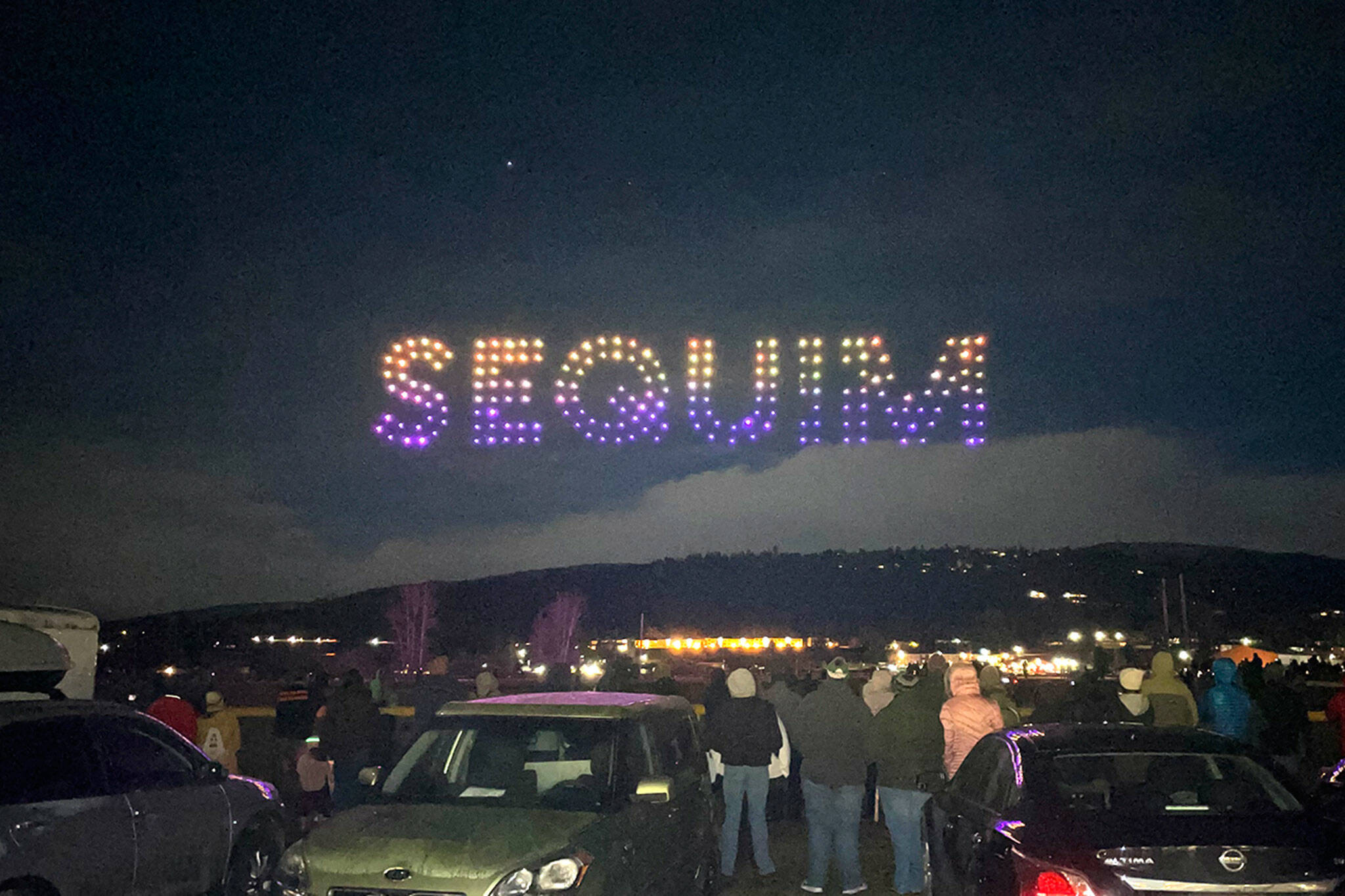 Sequim Gazette photo by Matthew Nash/ A shining “Sequim” made up of 200 drones flies above crowds in and near Carrie Blake Community Park for the Sequim Sunshine Festival’s Illuminated Drone Show.