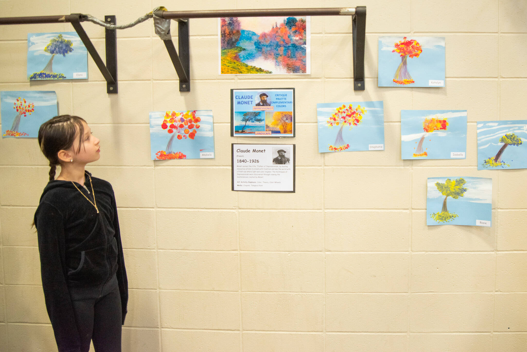 Sequim Gazette photo by Emily Matthiessen / Jayne Caulfield examines some of the artwork on display at Greywolf’s “Meet the Masters” art class exhibition on Tuesday. These pieces were made by 4th and 5th grade children after studying the impressionism and landscapes of Monet.
