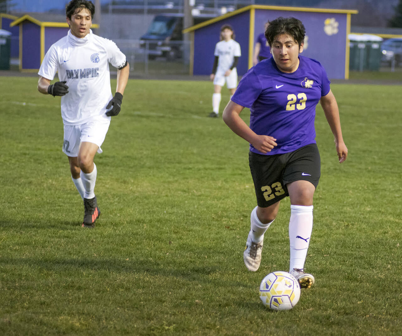 Sequim Gazette photo by Emily Matthiessen / Sequim’s Adrian Mendez, right, advances the ball in a home match-up against Olympic on March 21. The Wolves edged the Trojans, 1-0.