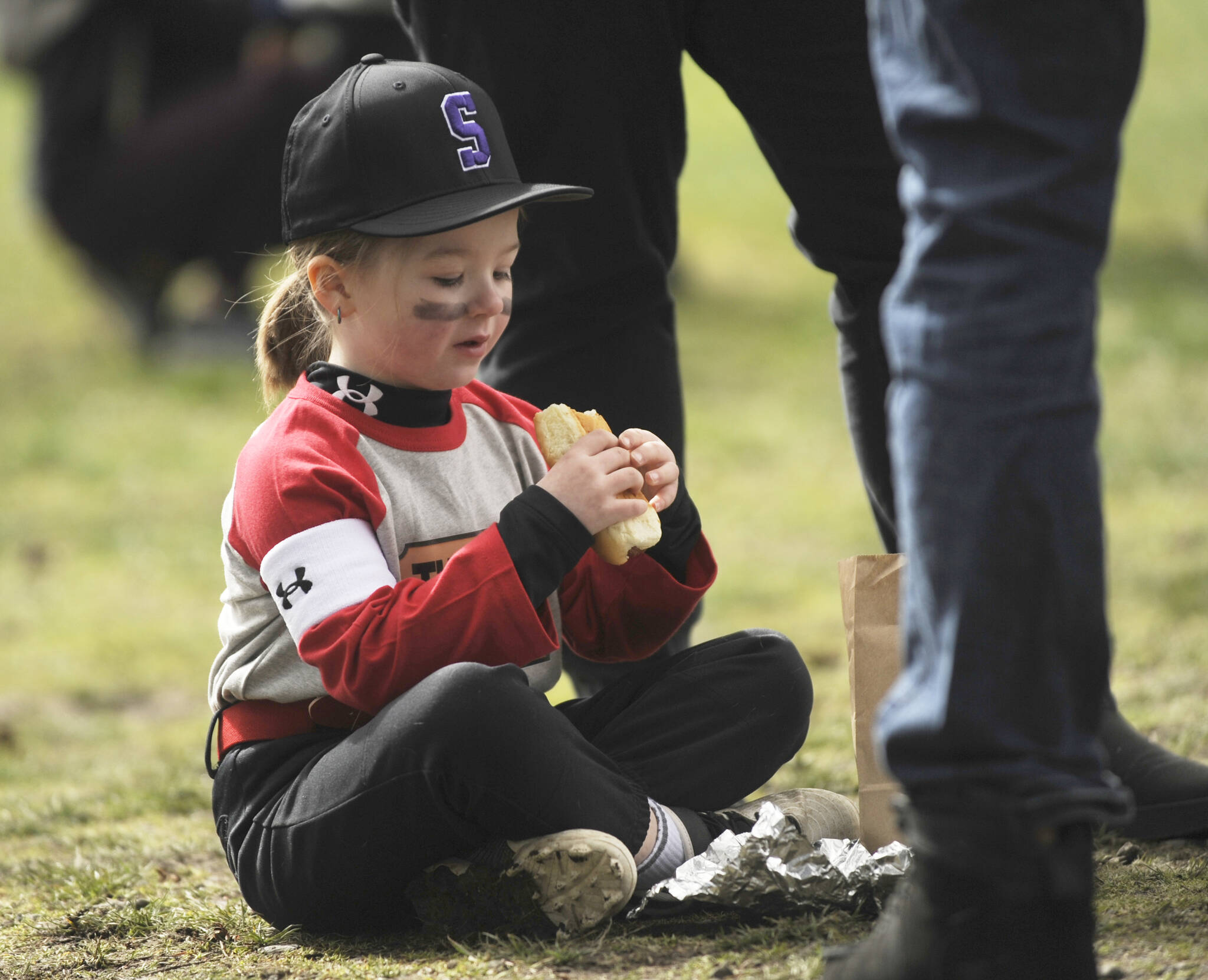 Lachlynn Henning, 5, enjoys a hot dog lunch at the Sequim Little League Opening Day ceremonies on March 25. Sponsored by Clallam County Professional Firefighters IAFF Local 2933, the event included free hot dog lunches for players and coaches.