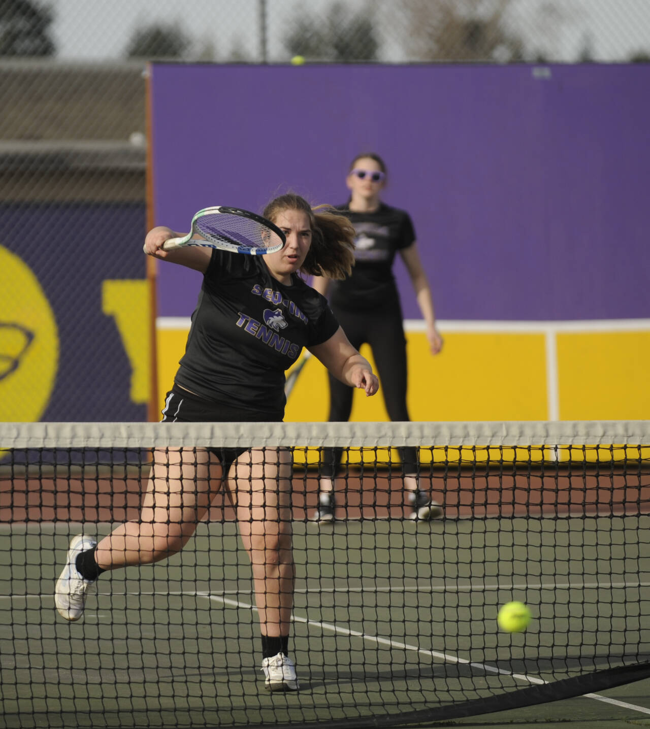 Sequim Gazette photo by Michael Dashiell / Sequim’s Sydney Hegtvedt, left, puts away a point as she and teammate Dani Herman take on Port Angeles’ Sarah Hancock and Cindy Liang in a No. 1 doubles match on March 29. The Sequim duo won in three sets – 6-3, 4-6, 6-3 — as the Wolves swept their rivals at home, 7-0.