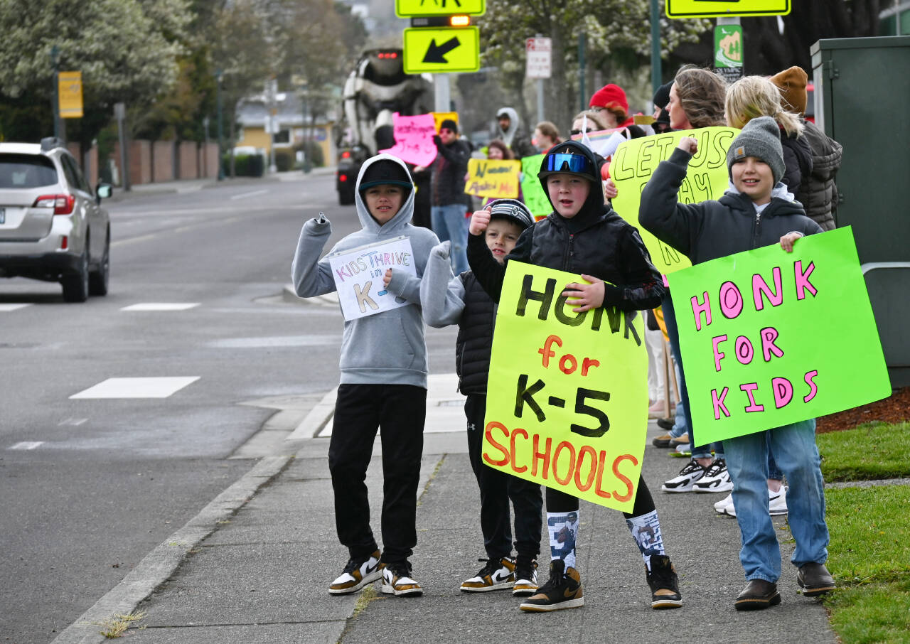 Sequim Gazette photo by Michael Dashiell / Sequim youths (from left) Trevor Dee, Weston Dee, Mason Henderson and Carson Stovall on Monday morning join a group of about 35 parents and students protesting the reconfiguration of Sequim’s two elementary schools. It was the first of two protests planned April 17 at Sequim School’s District Office with a larger rally planned for the afternoon.