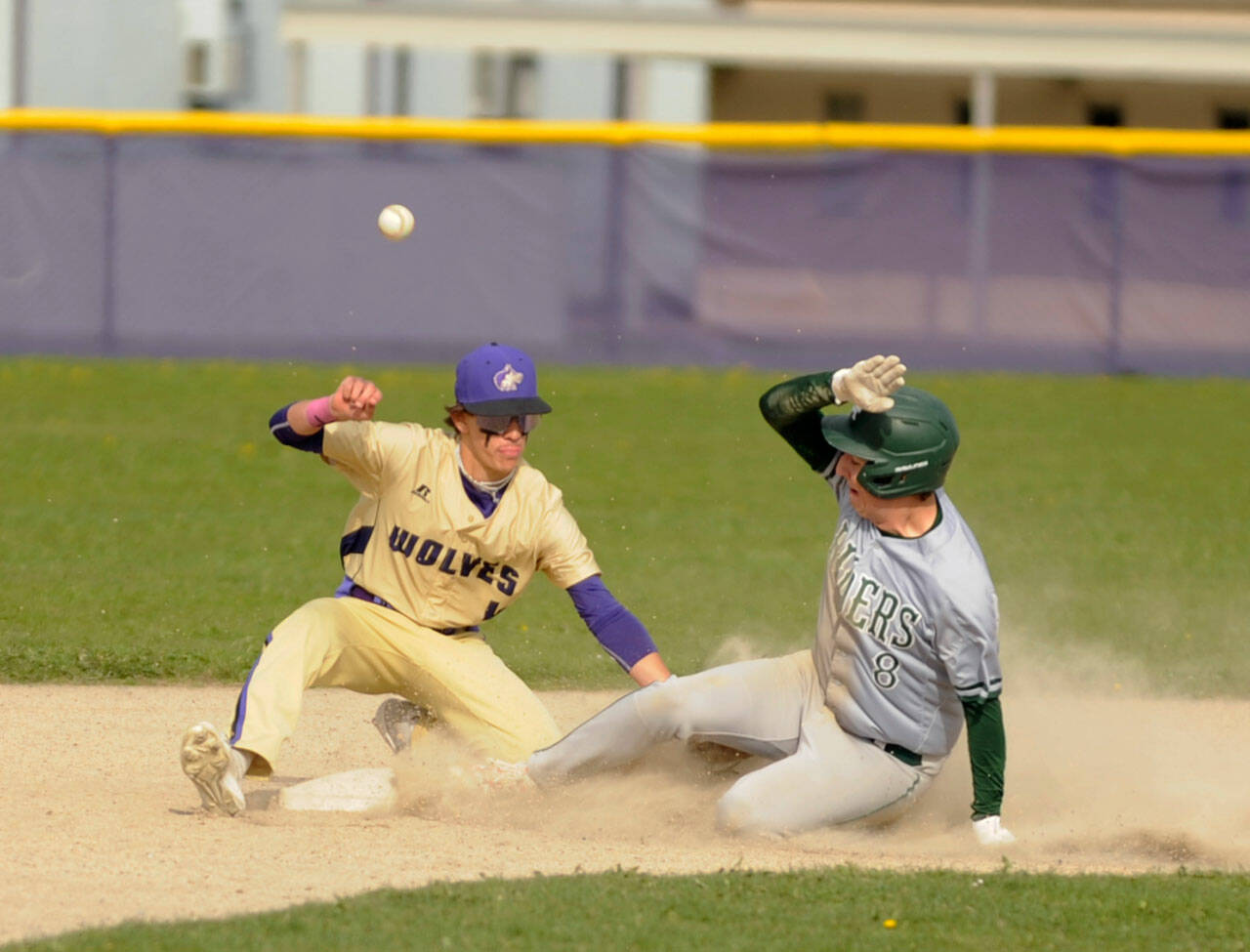 Sequim Gazette photo by Michael Dashiell / Bryan Laboy, left, looks to put the tag on Port Angeles’ Colton Romero in the third inning of an Olympic League match-up on April 13. The Roughriders scored five innings en route to a 12-2 win in Sequim.