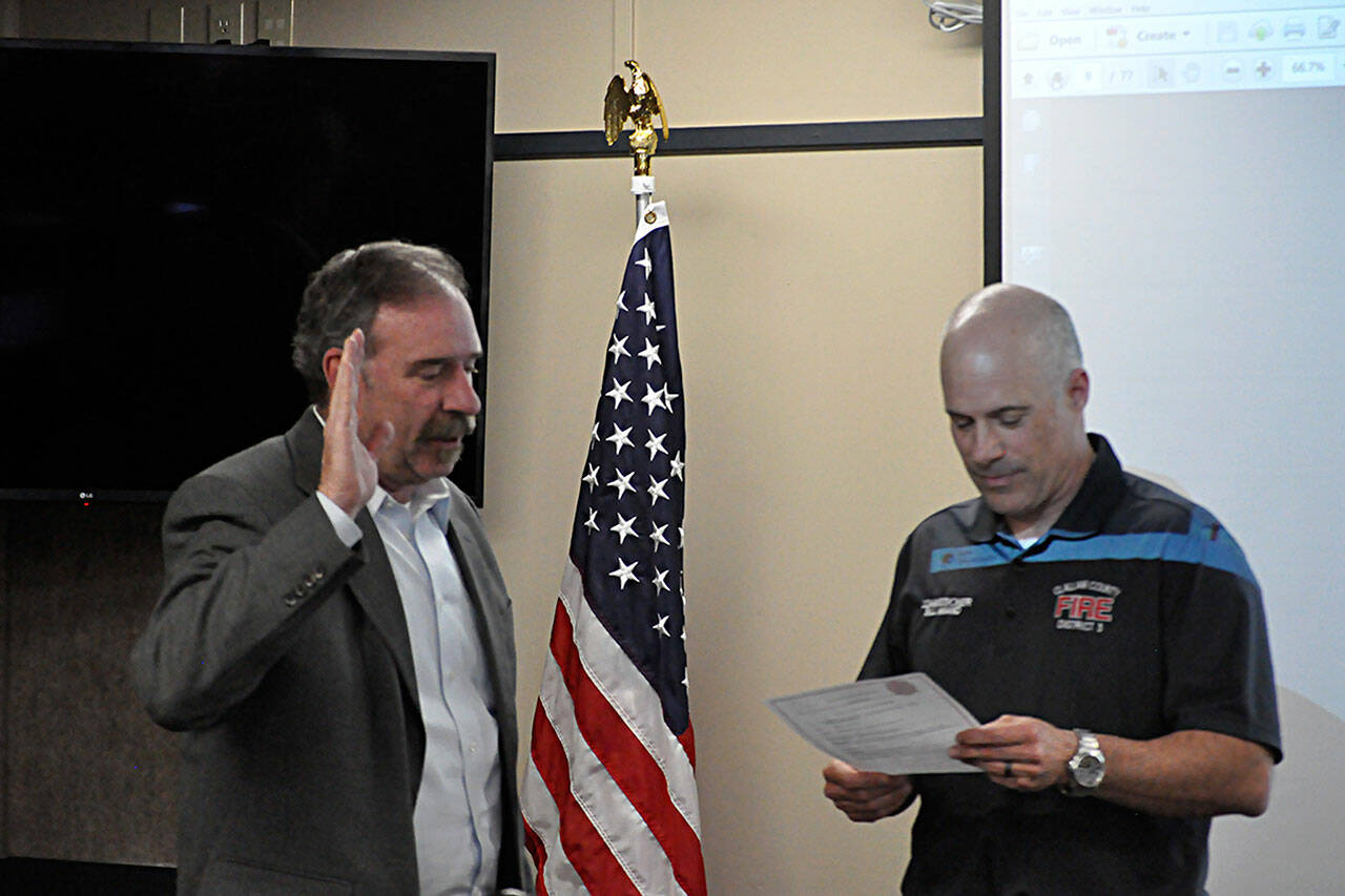 Sequim Gazette photo by Matthew Nash
Fire commissioner Bill Miano, right, swears in appointed commissioner Mike Mingee on May 2 during a meeting of the Clallam County Fire District 3’s board of commissioners. Mingee told commissioners in April he’s planning to file to run for the position this month.