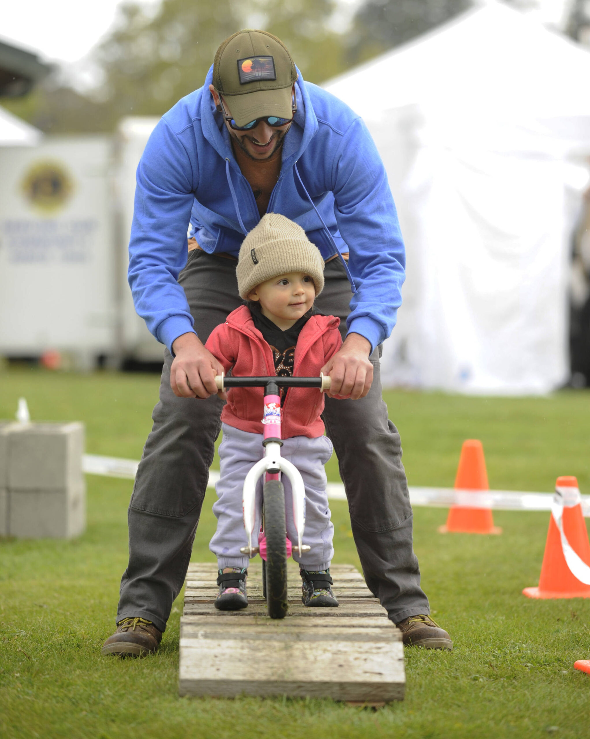 Sequim Gazette photo by Michael Dashiell / Luna Gondek, almost 2, of Sequim, is guided by John Gondek on a course set up by Lincoln Park BMX at the Family Fun Day event on May 6.