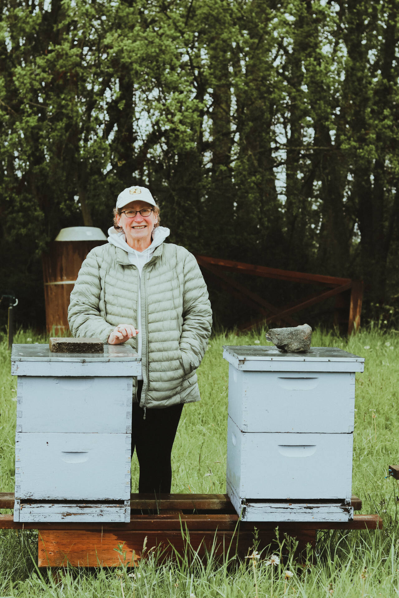 Photo courtesy of Sequim Farmers & Artisans Market / Meg Depew stands with two of the 65 hives Sequim Bee Farm manages across Clallam County.