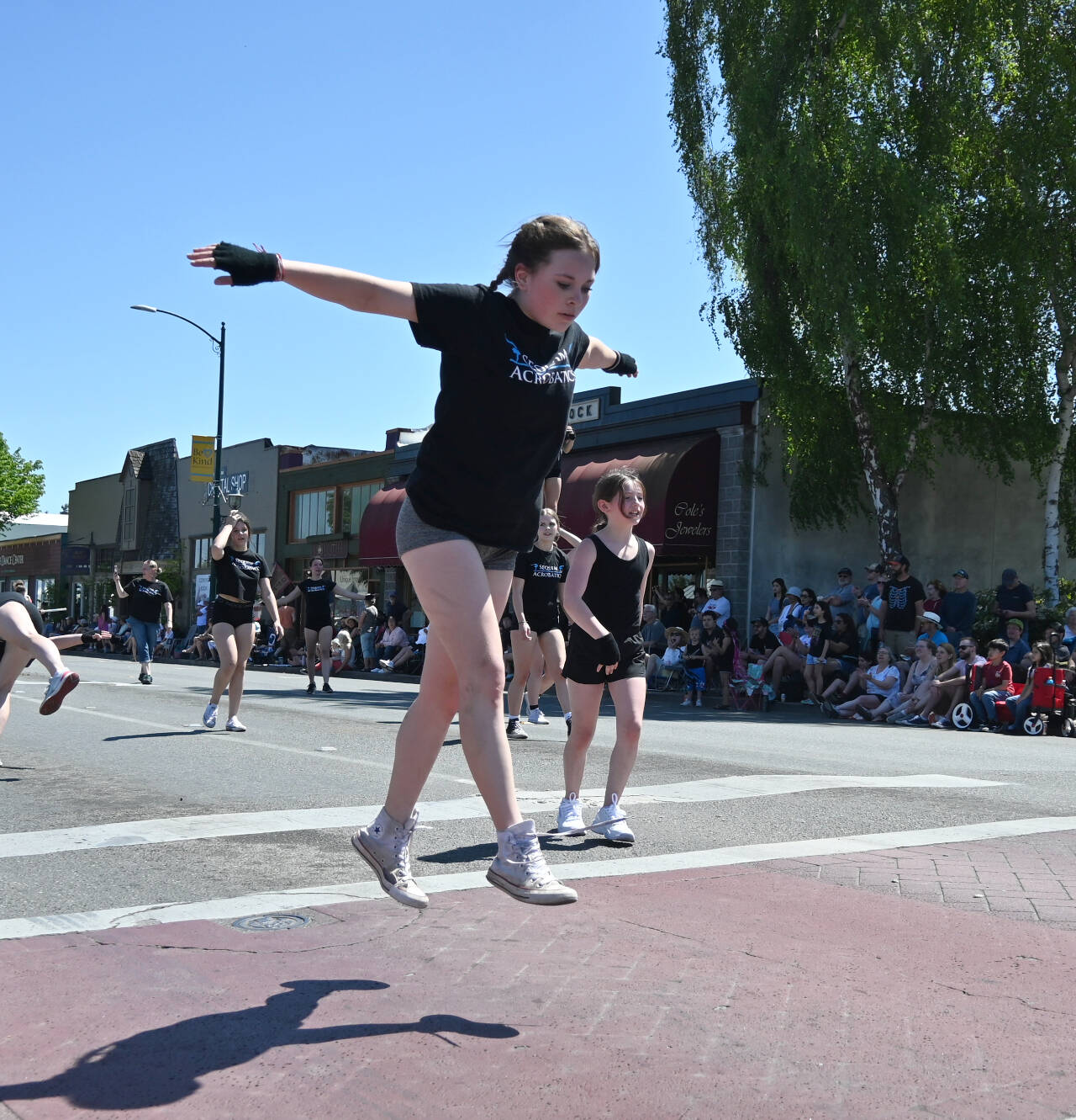 Sequim Gazette photo by Michael Dashiell / Sophie Clayton prepares a stunt as she down Washington Street as she and fellow Sequim Acrobatics athletes perform at the Sequim Irrigation Festival Grand Parade on May 13.