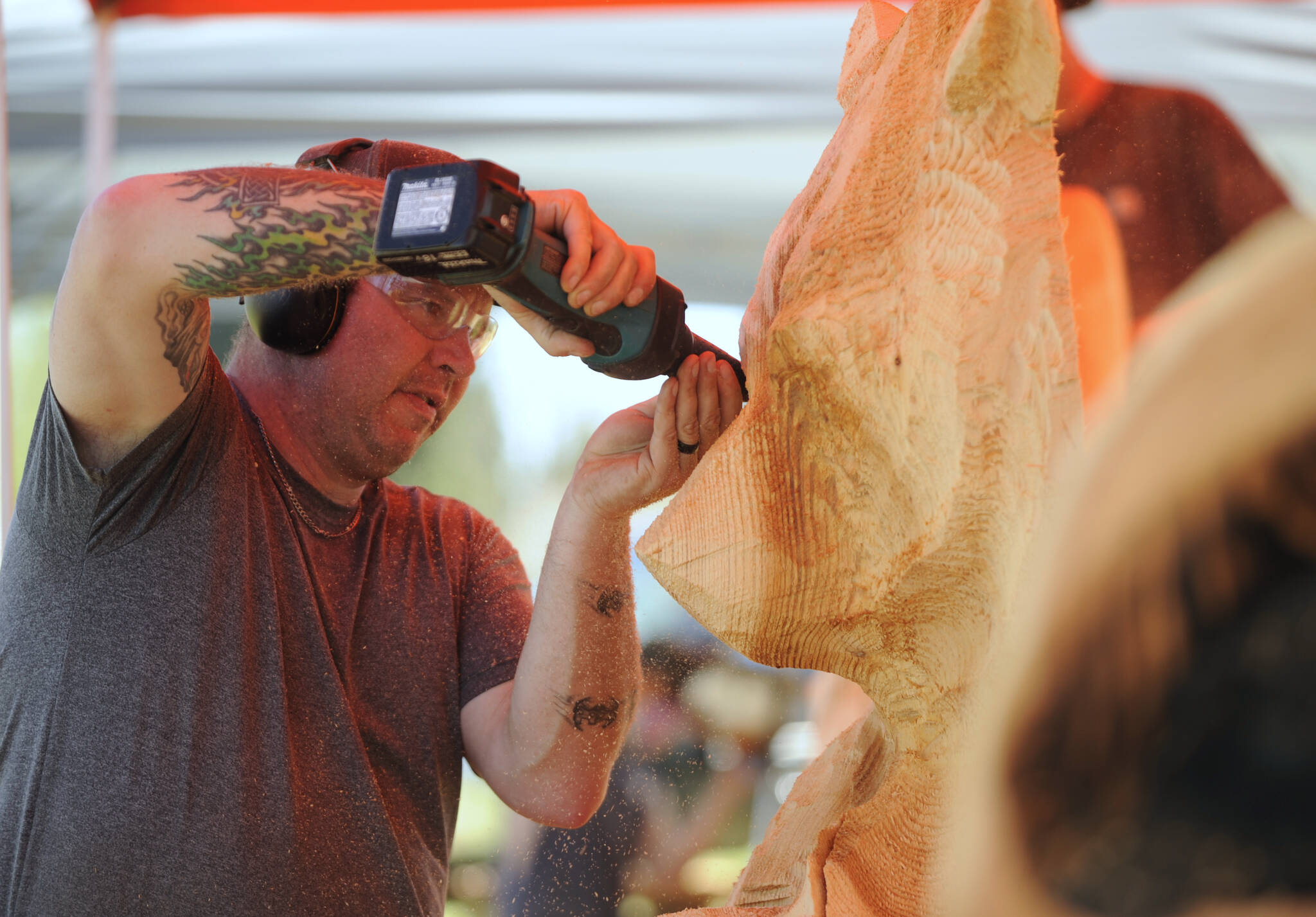 Sequim Gazette photo by Michael Dashiell / Nick Bielby of the Port Angeles-based Nicklby Wood Carving, works on a large bear sculpture at the Sequim Irrigation Festival Logging Show on May 12.