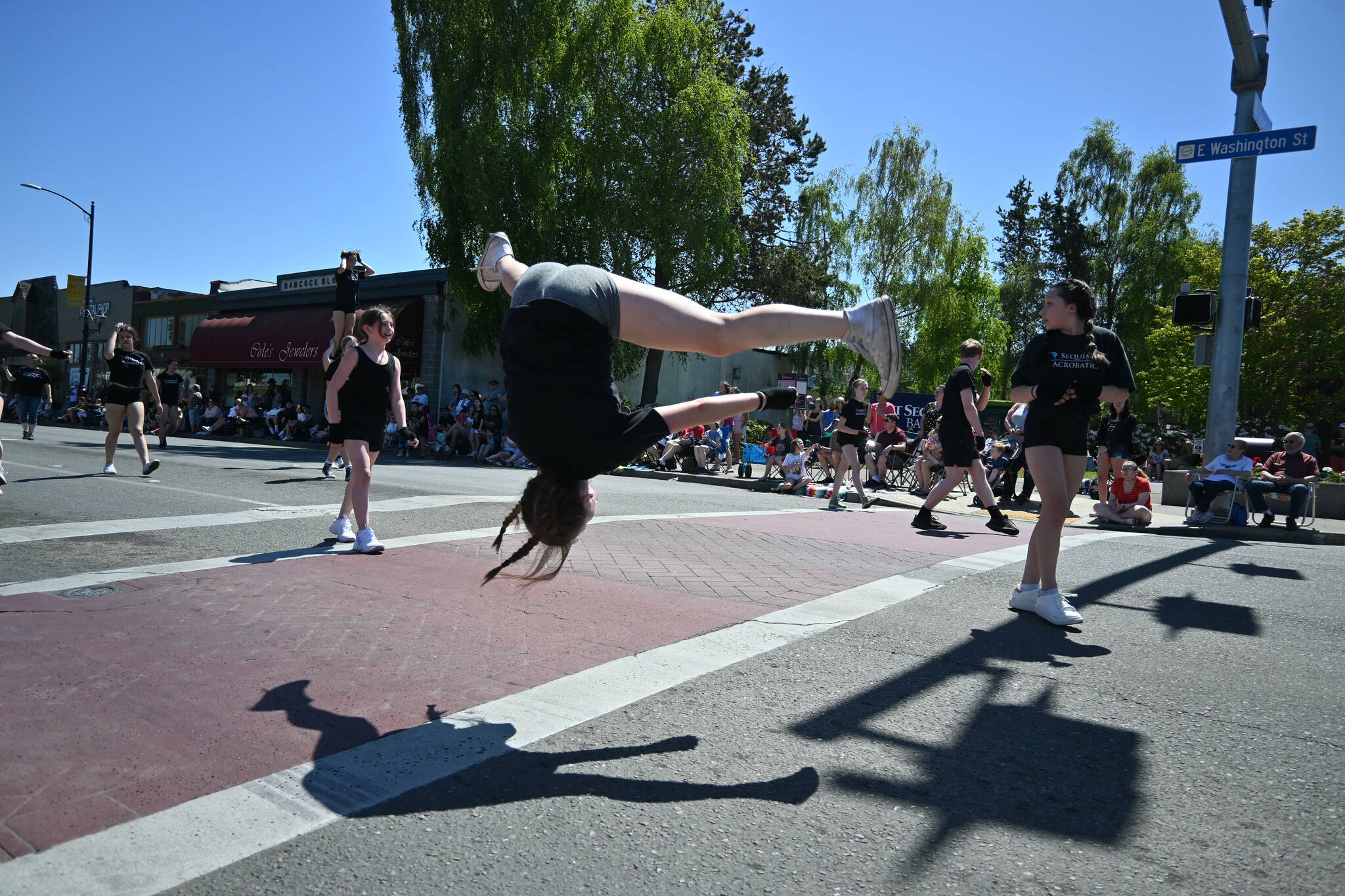 Sequim Gazette photo by Michael Dashiell / Amelie Martin goes head-over-heels as she and fellow Sequim Acrobatics athletes perform at the Sequim Irrigation Festival Grand Parade on May 13.