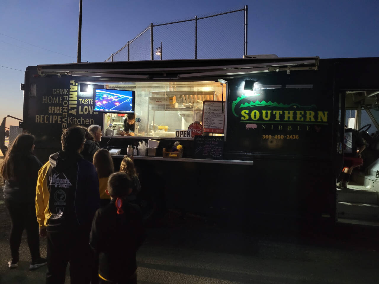 Sequim Gazette file photo by Michael Dashiell
Caleb Messinger and staff with the Southern Nibble food truck serve customers at a Sequim High soccer game in September 2022.