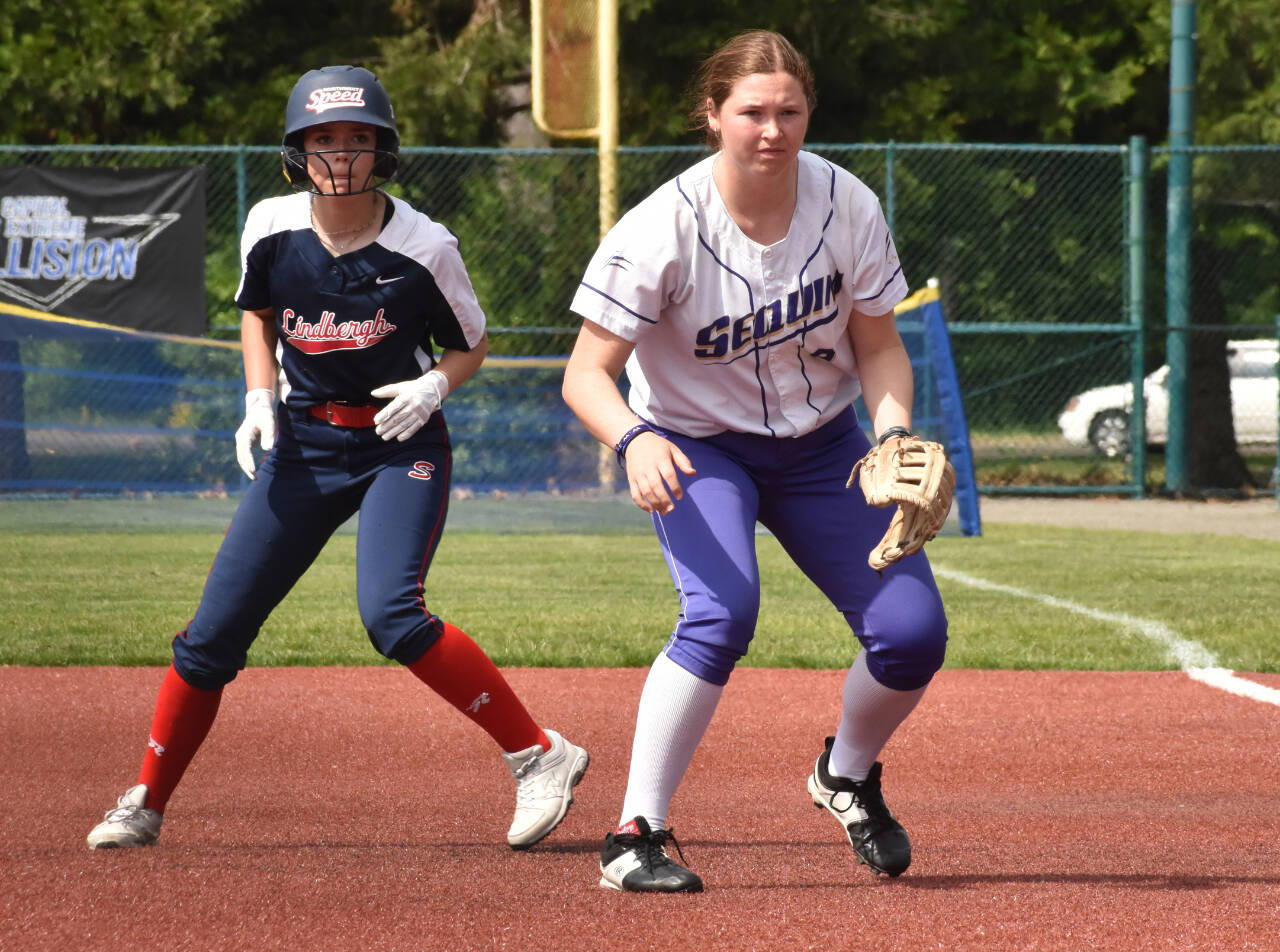 Photo by Kevin Hanson / Sequim's Sammie Bacon, right, keeps a Lindbergh baserunner close at first base in a West Central District tourney opener on May 20 in Lacey. Bacon had 4 RBIs in a 17-0 Sequim victory. The Wolves came within one win of a state 2A tourney berth.