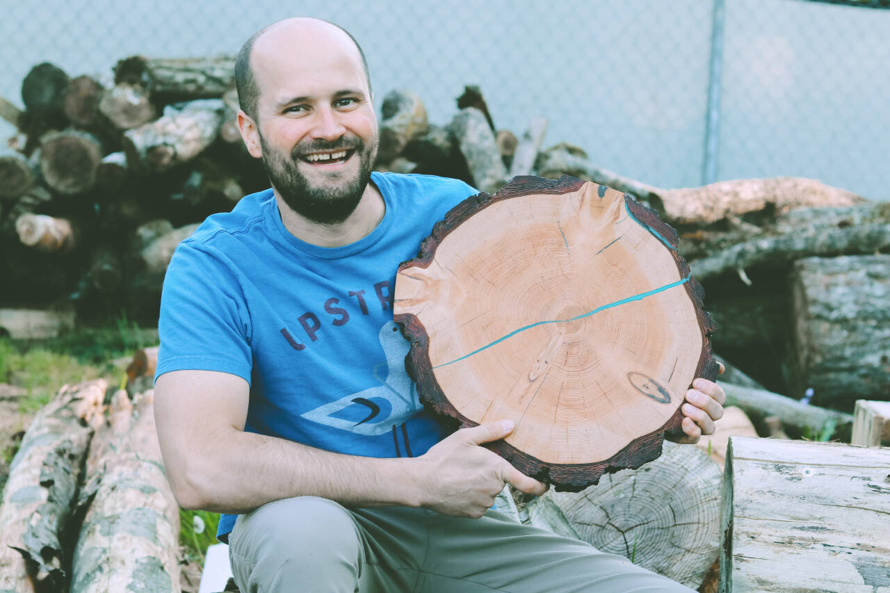 Photo courtesy of Sequim Farmers & Artisans Market 
Jack Just holds a customized wood round table top outside his workshop.