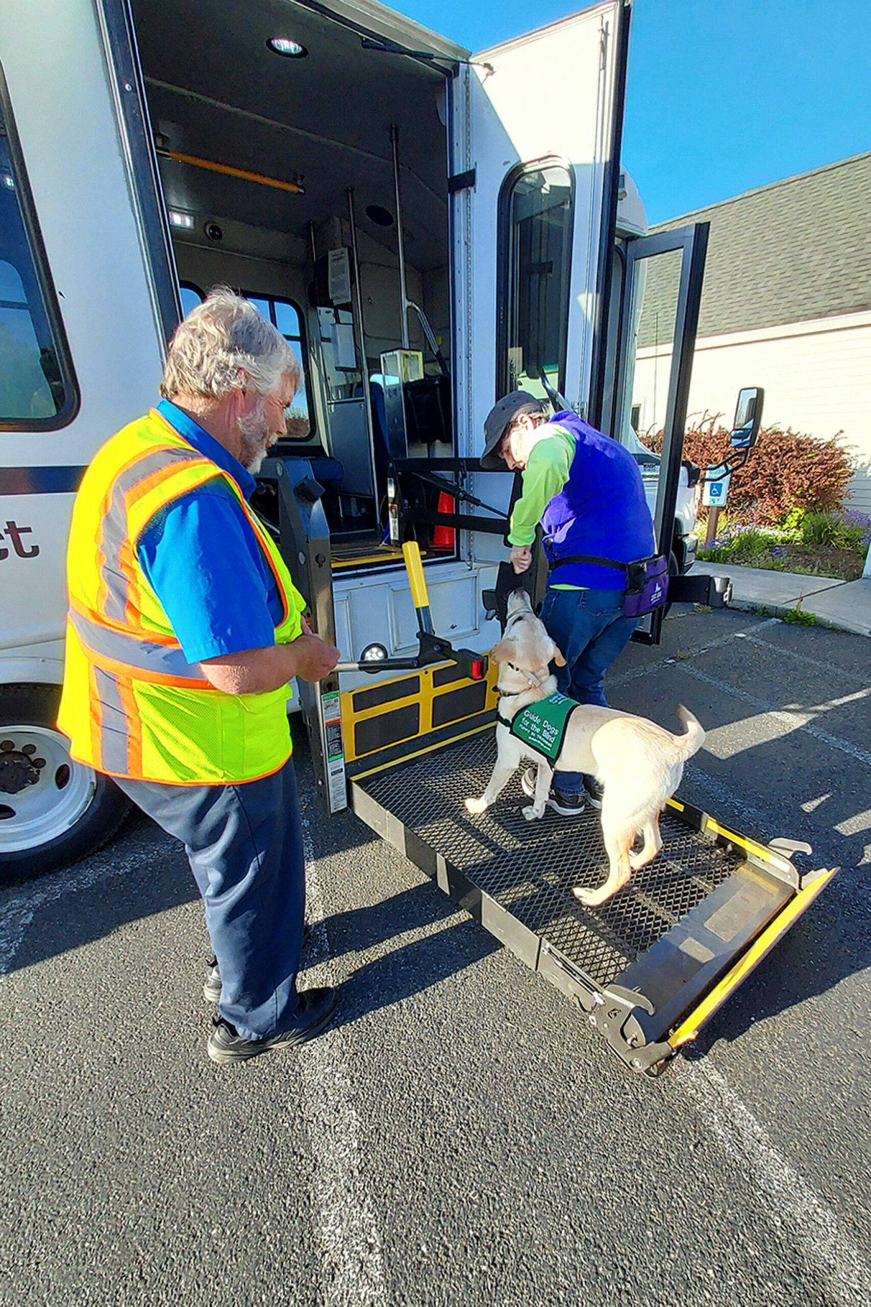 Clallam Connect driver Scott Estep helps Deb Cox and Sabrina the dog go up the bus lift as part of training on May 11 with the Sequim Puppy Raisers with Guide Dogs for the Blind.
