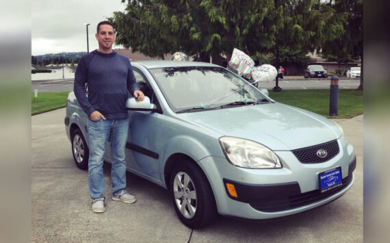Owner Michael Rocha with a previous year's prize vehicle given away by Rocha Family Auto Sales.